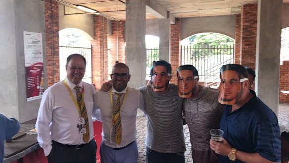 Cricket South Africa officials pose with crowd members wearing Sonny Bill Williams masks.