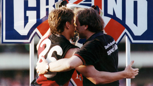 Essendon coach Kevin Sheedy and captain Mark Thompson embrace with the 1993 premiership cup