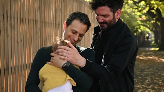Simon Abrahams and his partner Hamish with their four-month-old daughter who was born through surrogacy.