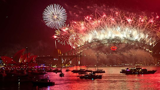 Spectator boats in Sydney Harbour look on as New Year's Eve fireworks erupt over the Sydney Harbour Bridge.