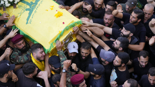 Hezbollah members carry the coffin of their comrade who was killed on Wednesday when a handheld device exploded, during a funeral procession in the southern suburbs of Beirut.