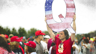 A Donald Trump supporter holds up a QAnon sign at a rally in 2018. 