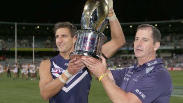 Matthew Pavlich and coach Ross Lyon hold the western derby trophy after defeating West Coast in 2013. 