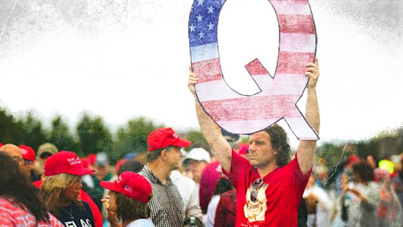 A Donald Trump supporter holds up a QAnon sign at a rally in 2018. 