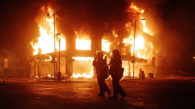 Riot police look on as fire rages through a building in Tottenham, north London, during the 2011 riots.