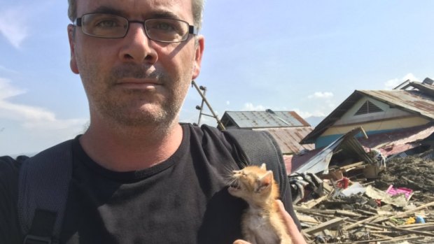 Correspondent James Massola holds kitten he rescued from a house in Petobo, Indonesia.