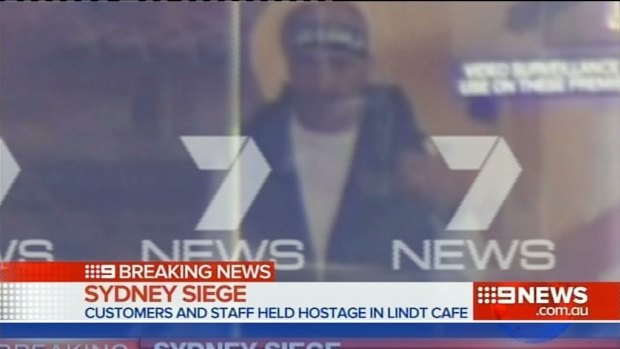 Man Haron Monis is seen through the window of the Lindt cafe. 