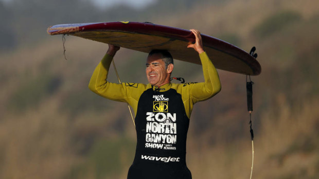 Garrett McNamara carries his longboard after a session at Praia do Norte beach in Nazare, Portugal.