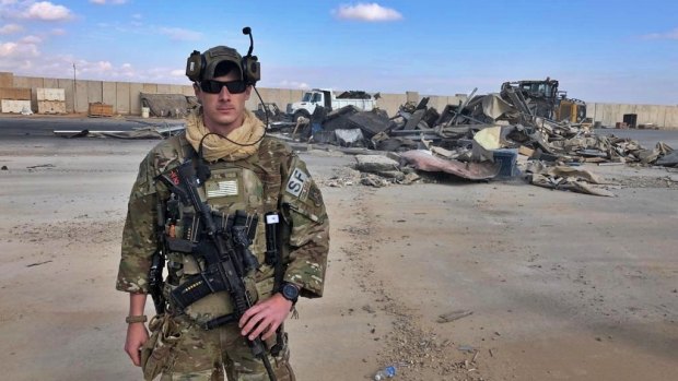 A US soldier stands while bulldozers clear rubble and debris at Ain al-Asad air base in Anbar, Iraq, Monday.