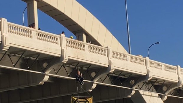 Extinction Rebellion protester Sean Nolan, 35, has been suspended from a rope on the William Jolly Bridge.
