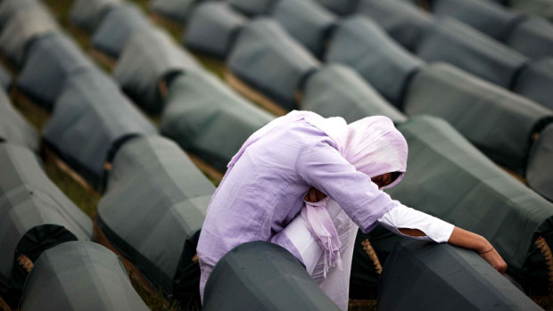 A Muslim woman prays beside the coffin of her relative, one of 534 victims of the 1995 Srebrenica massacre lined up for a joint burial in Potocari in 2009.