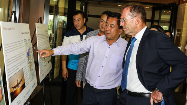 Jack Lam looks on as Tommy Jiang explains the multimillion-dollar redevelopment of the Twin Creeks Golf Club to Tony Abbott last year.