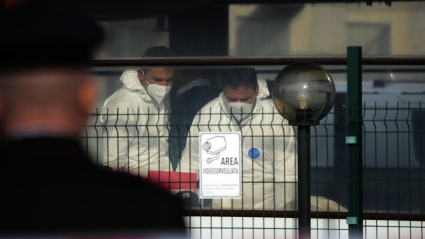 Forensic police officers inspect a bar where three people died after a man entered and shot in Rome on Sunday.