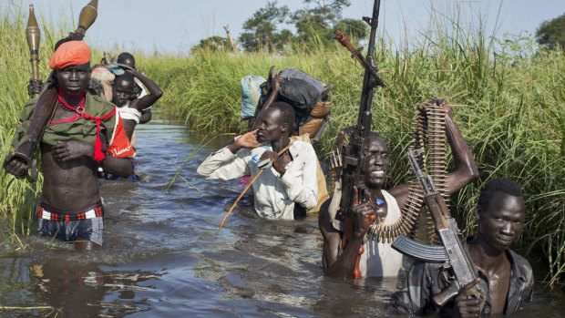Rebel soldiers patrol and protect civilians from the Nuer ethnic group, as they walk through floods to reach a makeshift camp for the displaced in South Sudan last year.