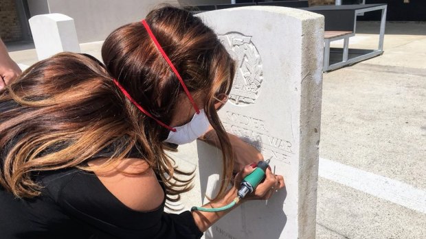Latika Bourke attempts etching a Commonwealth War Grave headstone at the Commonwealth War Graves Experience centre in Arras, France