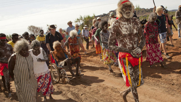 In 2011, East Arnhem land chief law man Jacob Nayinggul is pushed in his wheelchair by ANU historian Martin Thomas as he supervises proceedings as human remains are finally returned to their ancestral home in Gunbalanya, in Arnham Land. 