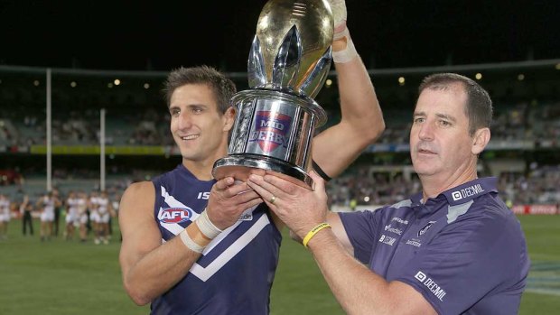 Matthew Pavlich and coach Ross Lyon hold the western derby trophy after defeating West Coast in 2013. 