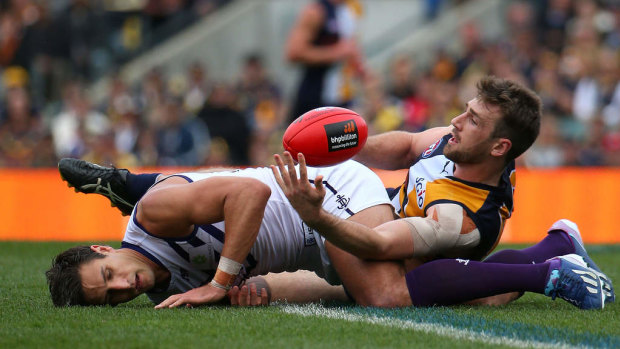 Eric Mackenzie of the Eagles tackles Matthew Pavlich of the Dockers after a marking contest.