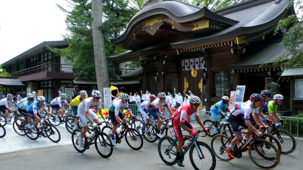 Road race cyclists in action at Musashiononomori Park on the first day of the Tokyo 2020 Olympic Games in Japan.