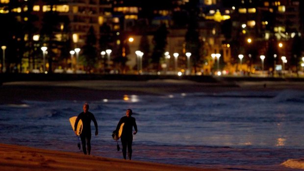 Two surfers exit the surf at North Steyne in Manly, in a file photo.