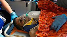 Rescue workers carry Hernán Alberto Gil Flores after he was pulled from the rubble.