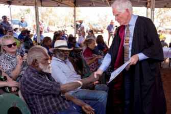 Federal Court Justice Michael Barker, right, shakes hands with David Stock after the Nyiyaparli won a native title claim over about 40,000 square kilometres of the Pilbara in 2018. 