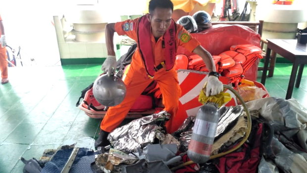 An Indonesian rescuer evacuating parts from a crashed Lion Air passenger plane in waters off Tanjung Karawang, West Java, Indonesia.