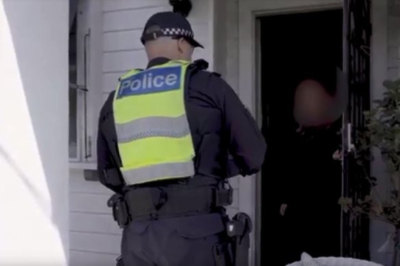 A Victoria police officer conducts a spot check on a traveller who returned from Bali.