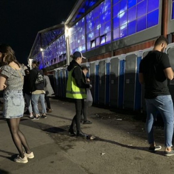 A research assistant queues at the portaloos, where discarded drugs were often found.