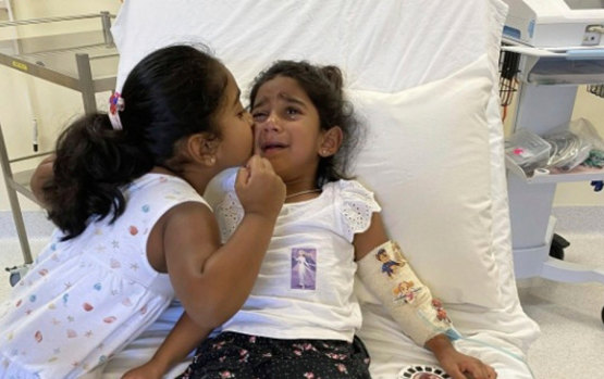 Tharnicaa and her sister Kopika in hospital on Christmas Island on June 6.