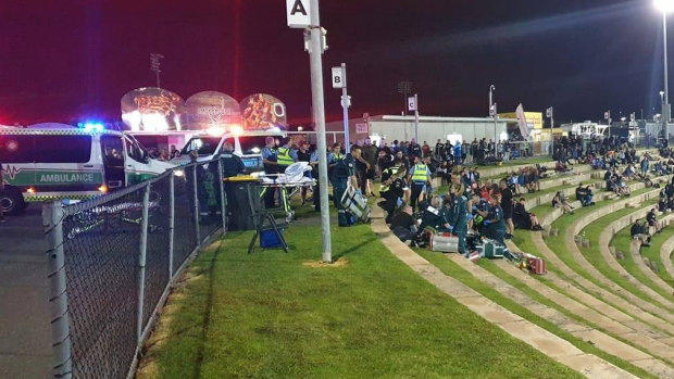 Ambulance officers attending to two people who were shot at Perth Motorplex on Saturday night.