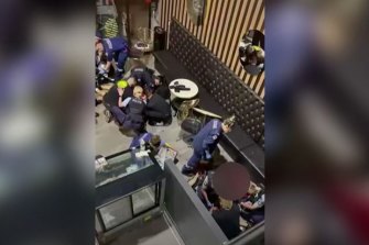 Police attempt to help the shooting victims in the foyer of the BodyFit gym on Tuesday night.