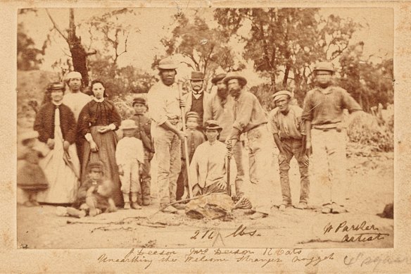Prospectors John Deason (left with crowbar) and Richard Oates (right with pick) with family and friends. A lump of quartz stands in for the nugget. 