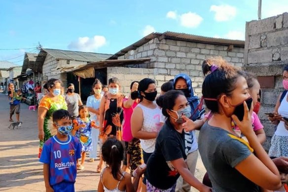 Dozens line up to get food packages. 