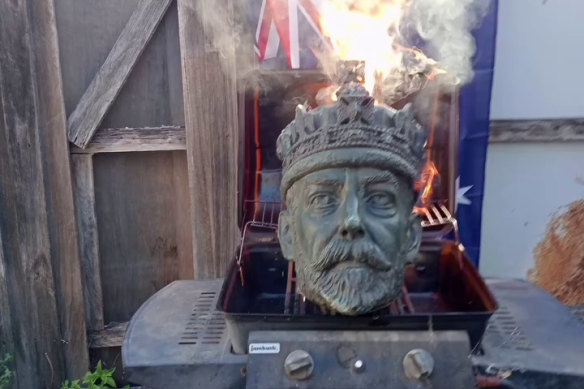The head from a statue of King George V is burnt in footage posted online on Australia Day. 