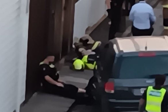 An image from police shows the officer lying on the ground after he had been hit by the SUV and shot the car’s occupants. Police have blurred the faces of the officers.