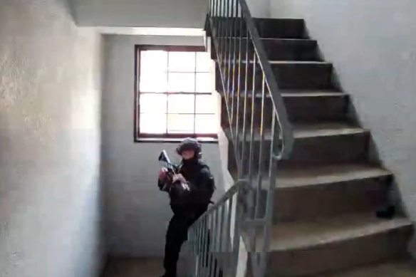 A police officer wearing tactical gear and carrying a gun is seen in the stairwell.</p>

<p>　　