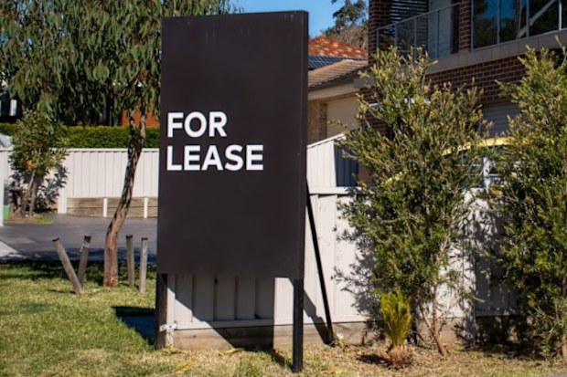 Black 'For Lease' sign outside a house.