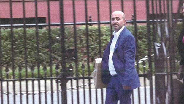 Property developer Jo Alha carrying a cardboard box of a model to a meeting with Daryl Maguire as seen in a photo submitted to the ICAC.