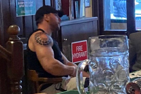 Jimeone Roberts drinking at The irish Times Pub with distinctive black sun tattoo.