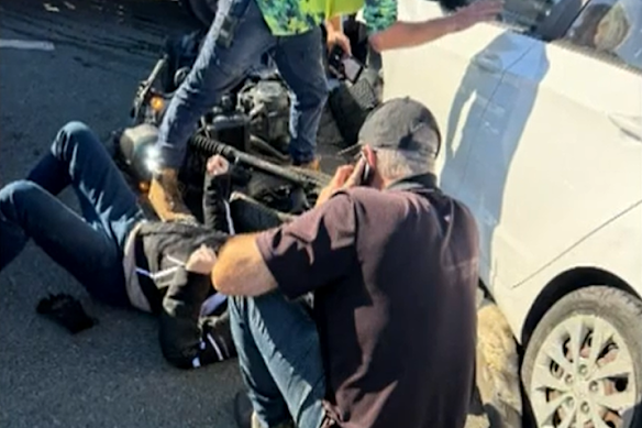 Passers-by helped free a 46-year-old motorbike rider trapped under a car following the crash on Gympie Road.