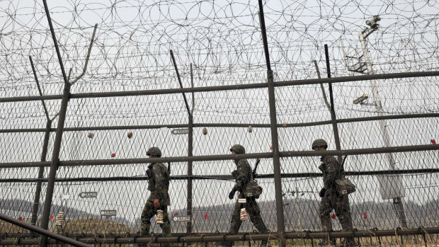 South Korean soldiers patrol along a military fence near the Demilitarised Zone.