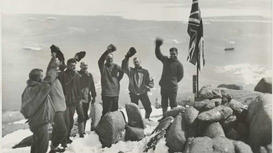 Sir Douglas Mawson and expedition members cheering the raising of the Union Jack flag at Proclamation Harbour, Enderby Land, Antarctica, ca. 1930.