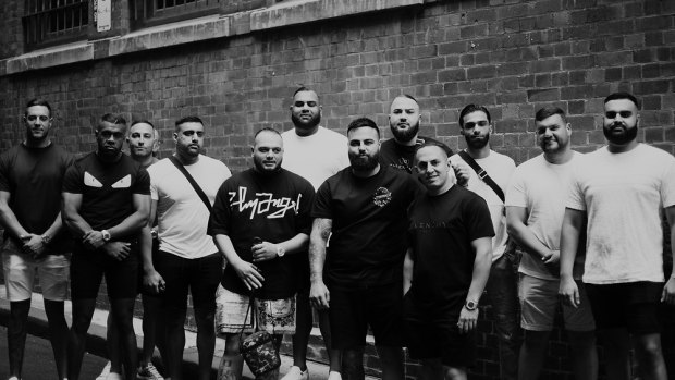 Far left is Stephen Bou-Abbse, second left is Joseph Vokai. Rapper Ay Huncho (real name Ali Younes) is fifth from left, holding a bag. The tall man in the white T-shirt behind him is Masood Zakaria. Immediately to the right of Ay Huncho is John Ray Bayssari, who has his arm around Andy Nahas. 