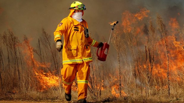An ACT rural firefighter performs prescribed burning in 2012.