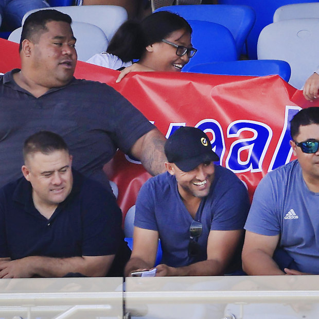 Deregistered player agent Isaac Moses (in blue shirt and black cap) sitting with the Suaalii family last month.