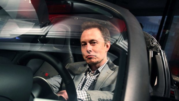Elon Musk, behind the wheel of a Tesla.