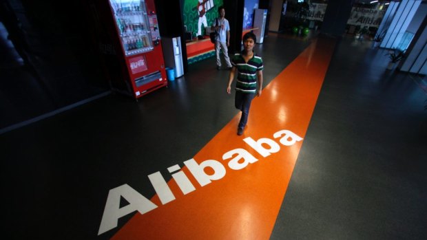 An employee walks past a logo of Alibaba at the company's headquarters in Hangzhou, Zhejiang province, China.