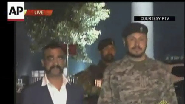 Wing Commander Abhinandan Varthaman, left, walks to cross the border into India, in Wagah, Pakistan, on Friday.