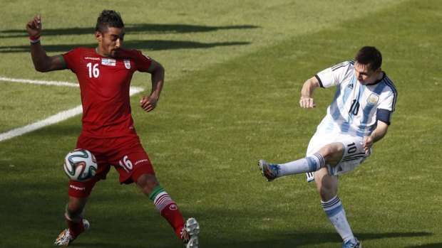 Elite company: Ghoochannejhad tries to stop Argentina's Lionel Messi at the 2014 World Cup.